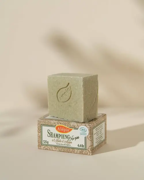 Biologische no-poo shampoo bar van Alepia met argan, op zijn kartonnen verpakking van 125 g