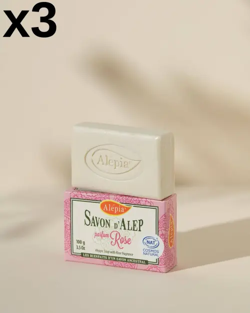Jabón de Alepo Prestige con Rosa Alepia en lote de 3, pastilla blanca grabada colocada sobre su caja rosa
