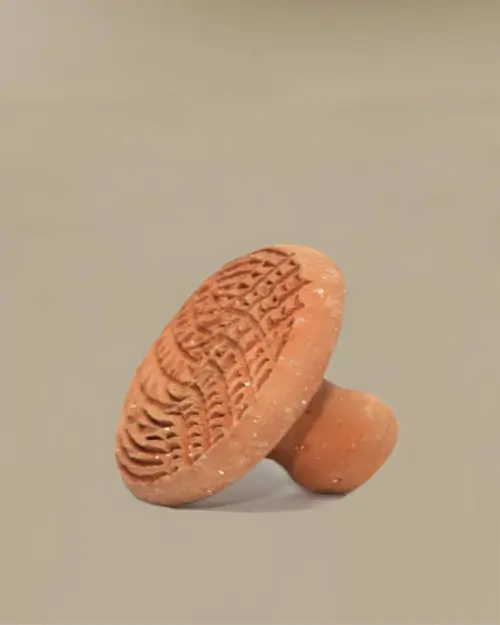 Disco exfoliante de terracota con asa y superficie grabada con motivos estriados