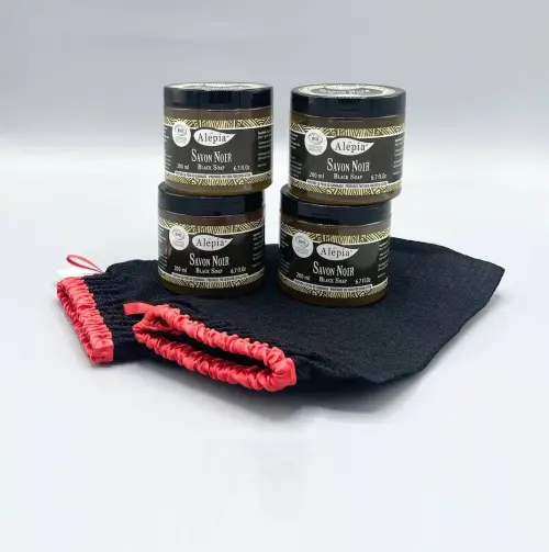 Hammam-Peeling-Set mit vier Töpfen schwarzer Seife von Alepia auf schwarzen Peeling-Handschuhen