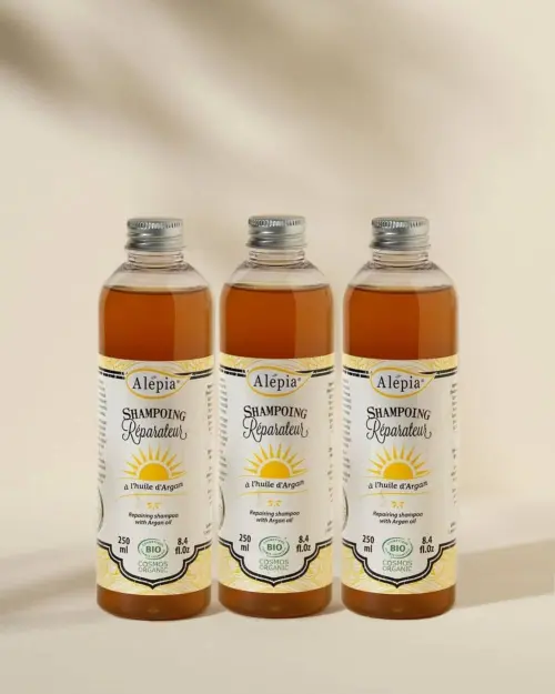 Drie biologische herstellende arganshampoo's van Alepia van 250 ml in transparante flessen met amberkleurige vloeistof