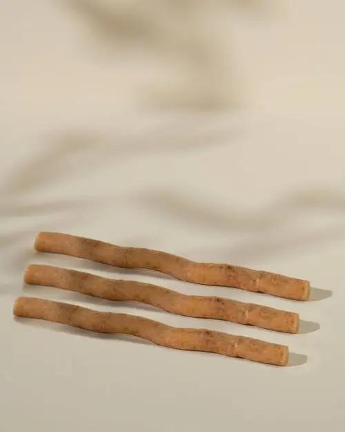 Siwak natuurlijke tandenborstel, drie ruwe stokjes naast elkaar op een beige achtergrond