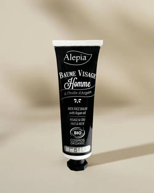 Baume visage Homme bio Alepia en tube noir de 30 ml à l'huile d'argan posé sur son bouchon