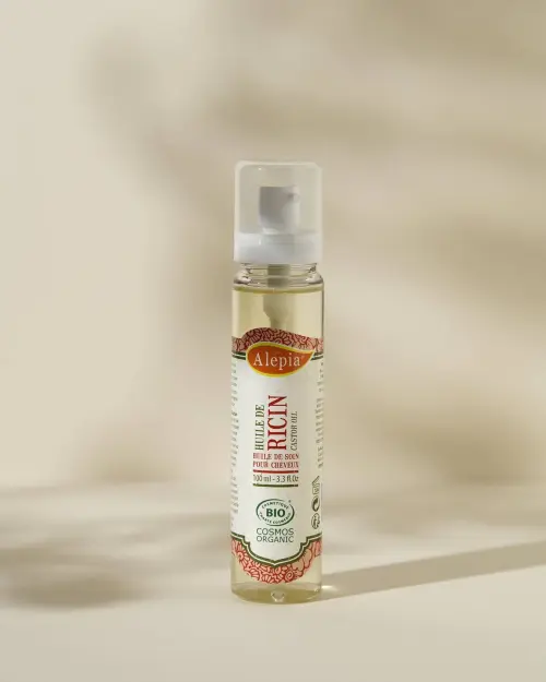 Olio di ricino bio Alepia 100 ml in flacone pump trasparente su fondo beige chiaro